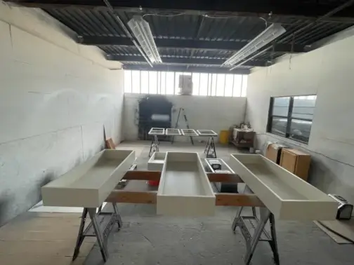 Industrial workshop with unfinished cabinets and workbenches.